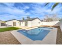 Private backyard featuring a refreshing swimming pool, green artificial turf and desert landscaping at 6597 Mountainwood Ln, Las Vegas, NV 89103