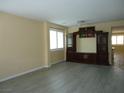 Open-concept living room with a large entertainment center and wood laminate flooring at 7929 Palace Monaco Ave, Las Vegas, NV 89117
