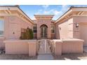 Elegant home entrance with a decorative wrought iron gate and a neatly maintained front garden at 10129 Elk Valley St, Las Vegas, NV 89178