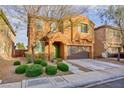 Charming two-story home boasts a well-manicured front yard with vibrant green bushes and neutral exterior at 10956 Hunting Hawk Rd, Las Vegas, NV 89179
