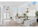Bright dining room featuring a modern glass table, chandelier and lots of natural light at 1401 Via Savona Dr, Henderson, NV 89052