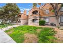 This exterior view shows a multi-story condo building featuring stairs and a well-maintained lawn at 221 Mission Catalina Ln # 202, Las Vegas, NV 89107