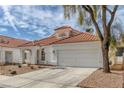 View of the house with red tile roof, low-maintenance landscaping and concrete driveway at 239 Highgate St, Henderson, NV 89074