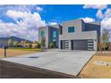 Contemporary two-story home with desert landscaping, concrete driveway, and a stylish black garage door at 2827 Richmar Ave, Henderson, NV 89074