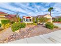 Well-manicured front yard with lush landscaping, decorative rock feature, and a charming red-tiled roof at 3032 Stratmoor Hills Ave, Henderson, NV 89052