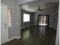 Open living room with hardwood floors, ceiling fan and view to outside through sliding glass doors at 3507 Pointe Vedra Ct, Las Vegas, NV 89122