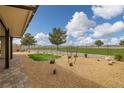 Spacious backyard with rock landscaping, partial grass and a view of the community golf course at 4096 E Cactus Canyon Dr, Pahrump, NV 89061
