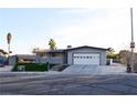 Single-story home featuring a two-car garage, concrete driveway, and manicured landscaping at 4417 Rita Dr, Las Vegas, NV 89121