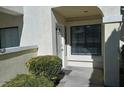 Close-up of the condo's front entrance, complete with trimmed bushes and neutral paint at 4865 S Torrey Pines Dr # 106, Las Vegas, NV 89103