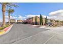 Community entrance and sign with lush landscaping and palm trees at 5204 Sunstone Mesa Dr, Las Vegas, NV 89166