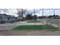 Wide driveway featuring artificial grass inserts, with a fenced yard and mountain views in the background at 5231 Smoke Ranch Rd, Las Vegas, NV 89108