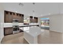 Modern kitchen featuring stainless steel appliances, a central island, and dark wood cabinets at 6325 Carmel Creek Ave, Las Vegas, NV 89139