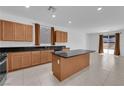 Well-appointed kitchen featuring black countertops, an island, and modern appliances for culinary enthusiasts at 7022 Feather Hill St, North Las Vegas, NV 89086