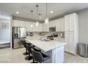 Modern kitchen with stainless steel appliances, white cabinetry, and spacious island with bar seating at 7061 Tilligerry St, North Las Vegas, NV 89084
