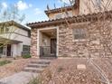 Charming two-story home featuring a stone facade, covered porch, and well-maintained desert landscaping at 715 Pickled Pepper Pl, Henderson, NV 89011