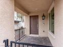 Close-up of front porch showing brick flooring, a security gate, and a classic outdoor lantern at 715 Pickled Pepper Pl, Henderson, NV 89011
