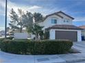 Charming two-story home with a well-maintained lawn and a two-car garage in a residential neighborhood at 8396 Yamhill St, Las Vegas, NV 89123