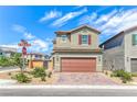 Two-story home featuring a tidy front yard, brick driveway, and attached two-car garage at 8502 Torozo Ave, Las Vegas, NV 89149