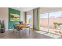 Bright dining area with a table, four chairs, modern art, and sliding glass doors to the yard at 9932 Ullom Dr # 5, Las Vegas, NV 89141