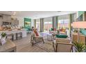 Bright and airy living room with modern furniture, light wood floors, and large windows with colorful drapes at 9932 Ullom Dr # 5, Las Vegas, NV 89141