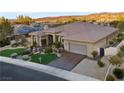 Beautiful desert home boasts mature landscaping, stone accents and attached garage at 10 Greely Club Trl, Henderson, NV 89052