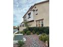 Multi-story townhome showcasing landscaped front yard and appealing architectural details at 11489 Belmont Lake Dr # 106, Las Vegas, NV 89135