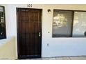 Exterior of apartment featuring a dark wooden door with security grate and windows at 2724 Otter Creek Ct # 101, Las Vegas, NV 89117