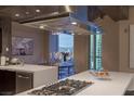 Modern kitchen with stainless steel range hood and a dining area with city views through large windows at 2777 Paradise Rd # Ph 3001, Las Vegas, NV 89109