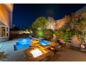 Tranquil backyard featuring a sparkling pool with water features, a cozy fire pit, and serene landscaping at 3459 Ridge Meadow St, Las Vegas, NV 89135