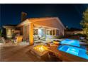 Covered patio with ample seating, a fire pit, and a sparkling pool provides ideal outdoor living space at 3459 Ridge Meadow St, Las Vegas, NV 89135