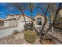 Charming single-story home showcasing desert landscaping, a two-car garage, and an inviting front entrance with brick accents at 3756 Prairie Orchid Ave, North Las Vegas, NV 89081