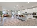 Open kitchen features white cabinetry, granite counters, an island with seating and stainless appliances at 4050 Peaceful Dune St, Las Vegas, NV 89129