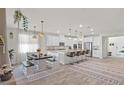 Open kitchen features white cabinetry, granite counters, island with seating, and dining area at 4050 Peaceful Dune St, Las Vegas, NV 89129