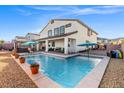Backyard features a pool, covered patio with seating, and gravel landscaping at 4050 Peaceful Dune St, Las Vegas, NV 89129