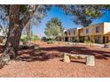 Two-story townhomes with well-maintained landscape featuring trees and mountain views in the background at 431 Las Casitas Way, Las Vegas, NV 89121