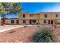 A sunny day view of townhomes with red rock landscaping and sidewalk pathways at 431 Las Casitas Way, Las Vegas, NV 89121
