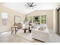 Bright, modern living room featuring neutral tones, a white sofa, and large windows with natural light at 441 Beautiful Hill Ct, Las Vegas, NV 89138
