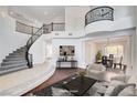 Grand foyer showcasing a curved staircase, high ceilings, and elegant chandelier at 5148 Villa Vecchio Ct, Las Vegas, NV 89141