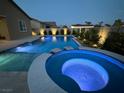 Inviting pool and spa with vibrant underwater lighting in a landscaped backyard, perfect for relaxation and entertainment at 5371 Brevin Ct, Las Vegas, NV 89131