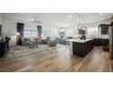 Bright, open-concept living room features wood-style tile flooring, stylish furnishings and lots of natural light at 6225 Gambetta St, Las Vegas, NV 89115