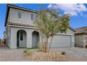 Two-story home with desert landscaping in front, two-car garage, and arched front porch at 7532 Lush Oasis Ave, Las Vegas, NV 89113