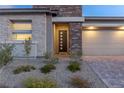 Inviting front exterior featuring stone accents and a modern front door with multiple glass panes at 912 Calluna Hills Ln, Las Vegas, NV 89138
