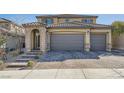 Two-story home showing a three-car garage with a brick-paved driveway and tiled roof at 10173 Skye Saddle Ave, Las Vegas, NV 89166