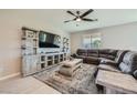 Comfortable living room featuring a ceiling fan, media center and plush sectional sofa at 10173 Skye Saddle Ave, Las Vegas, NV 89166