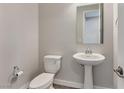 Powder room features modern fixtures including a pedestal sink and toilet at 10619 Carnes Ave, Las Vegas, NV 89166