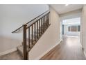 Bright hallway boasts wood-look floors, carpeted stairs with wood railing and natural light at 10619 Carnes Ave, Las Vegas, NV 89166