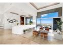 Bright open-concept living room featuring floor-to-ceiling windows with city views and stylish modern furnishings at 1484 Macdonald Ranch Dr, Henderson, NV 89012
