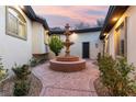 Charming courtyard with a central tiered fountain, flowering plants and a stamped concrete walkway at 211 Granite Ct, Boulder City, NV 89005