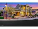 Beautiful two-story home with a portico, balcony, manicured landscaping highlighted at dusk at 2908 Ferrand Ct, Henderson, NV 89044