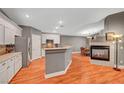Open-concept kitchen features white cabinets, stainless steel appliances, and adjacent dining area with a fireplace at 3723 Robin Knot Ct, North Las Vegas, NV 89084